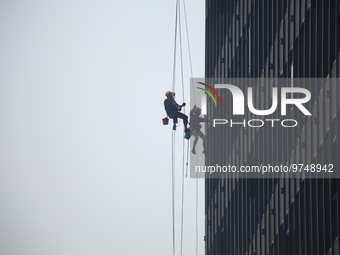 

Workers are hanging on by the rope as they clean the windows of a high-lying building in the Nepali capital, Kathmandu, on March 15th, 202...