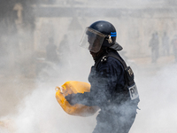 A policeman throws some water on a fire, on March 16, 2023. Security forces were deployed in the Senegalese capital ahead of a politically-c...