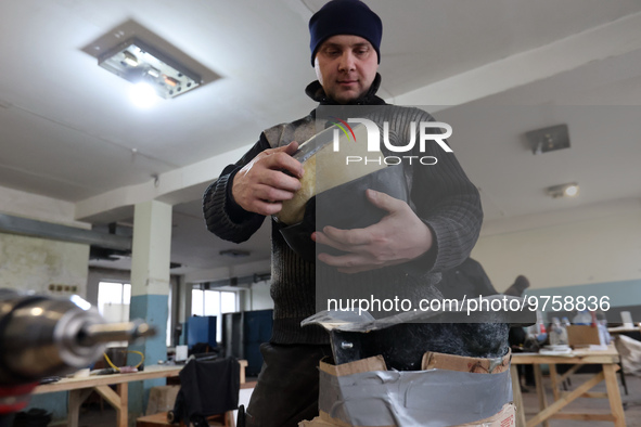 KHARKIV, UKRAINE - MARCH 16, 2023 - An employee works on a military helmet at the Ukrainian Spring Center, Kharkiv, northeastern Ukraine.NO...