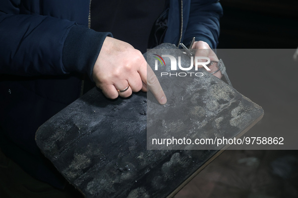 KHARKIV, UKRAINE - MARCH 16, 2023 - A person shows the results of tests performed on a ballistic plate manufactured at the Ukrainian Spring...