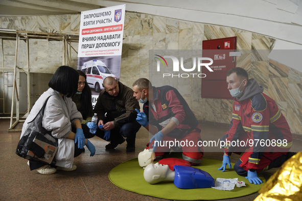 People listen to an instructor during a first aid training at one of the metro stations in Kyiv, Ukraine, on March 17, 2023. Specialists and...