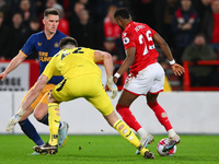 Emmanuel Dennis of Nottingham Forest puts pressure on Nick Pope of Newcastle United during the Premier League match between Nottingham Fores...