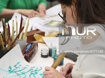 People take part in a traditional Farsi calligraphy workshop during Nevruz celebrations in Toronto, Canada, on March 18, 2023. Nevruz (Noroo...