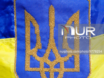 Coat of arms of Ukraine is seen on an Ukrainian flag during a daily demonstration of solidarity with Ukraine at the Main Square on 389th day...