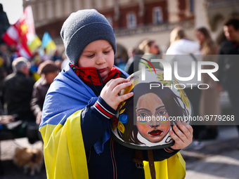 A boy holds a hand-painted helmet with Ukrainian decorations during a daily demonstration of solidarity with Ukraine at the Main Square on 3...