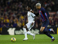 Vinicius Junior left winger of Real Madrid and Brazil and Ronald Araujo centre-back of Barcelona and Uruguay compete for the ball during the...