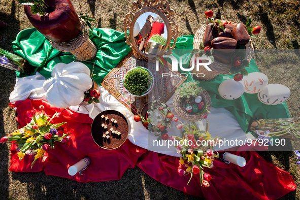 Items celebrating Nowruz sit on an Iranian flag during an event marking the holiday on the National Mall. The holiday has its roots in Zoroa...