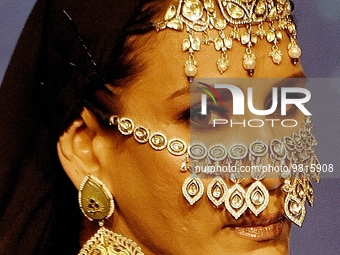A model wearing jewellery poses for a photo on a runway during a Jewellery fashion show of India Bullion And Jewellers Association Ltd (IBJA...