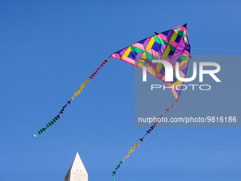 A colorful kite flies near the Washington Monument, during a kite event at the annual Cherry Blossom Festival.  The month-long festival cele...