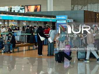 Passengers with luggages walk and wait check-in with Korean Air at Incheon International Airport on March 30, 2023, South Korea.According t...