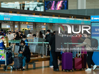 Passengers with luggages wait check-in with Korean Air at Incheon International Airport on March 30, 2023, South Korea. According to Incheo...