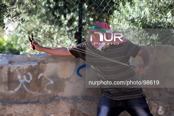 Ramallah, West Bank, Palestinian Territories, May 02, 2014: A Palestinian protester uses a sling to hurl stones towards Israeli soldiers dur...
