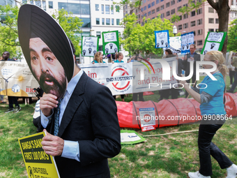 A man wears a mask of incoming World Bank President Ajay Banga during a 
