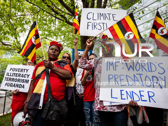 Ugandan protesters join climate activists in a rally and march at World Bank headquarters during its spring meetings with the International...