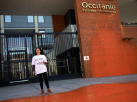 An activist speaks in front of the painted entrance of the Conseil Regional Occitanie. Three campaigners of  'Derniere Renovation' (ie 'Last...