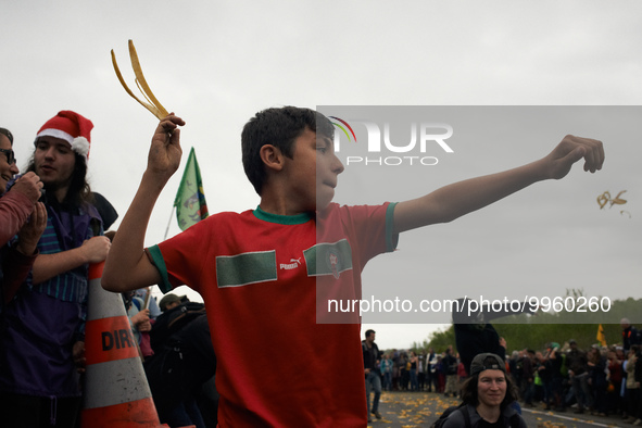 A boy throws a banana peel during a banana peels battle during the march. More than 8000 protesters marched 12km against the planned A69 hig...
