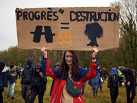 A woman holds a placard reading 'Progress = destruction' during the march. More than 8000 protesters marched 12km against the planned A69 hi...