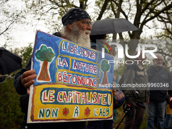 A man holds a placard reading 'Let's free Nature and let's concreting the capitalism. No the the A69'. More than 8000 protesters marched 12k...