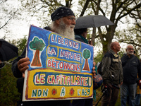 A man holds a placard reading 'Let's free Nature and let's concreting the capitalism. No the the A69'. More than 8000 protesters marched 12k...
