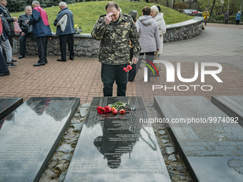 A man honors with flowers the memorial of the dead Chernobyl workers during the celebrations in Kiev of the 37th anniversary of the Chernoby...