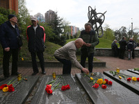 People lay flowers to a memorial to firefighters and workers, who died following the Chernobyl Nuclear Power Plant disaster, during a commem...
