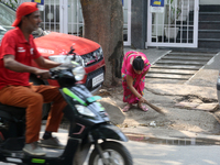 Maid (servant) sweeps the area in front of her owners house in Delhi, India on May 07, 2022. (