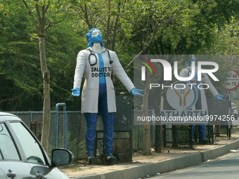 Figures outside a hospital saluting the doctors and healthcare professionals during the novel coronavirus (COVID-19) pandemic in Delhi, Indi...