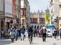 Visitors walk on Grodzka street in the Old Town of Krakow, Poland on April 26, 2023. Despite inflation and a crisis connected with the war i...