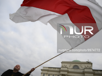 A man flies the Belarusian opposition flag at a rally on the 37th anniversary of the Chernobyl nuclear reactor disaster in Warsaw, Poland on...