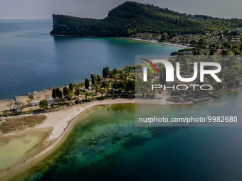 A drone view of people walking towards San Biagio Island, also known as Rabbit Island, on Lake Garda as the lake's water levels recede due t...