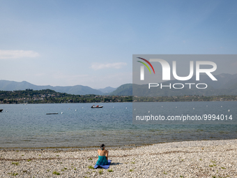 A woman sunbathes on the shore of Lake Garda as water levels recede due to a severe drought in Manerba, Italy, on April 28, 2023. The water...