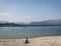 A woman sunbathes on the shore of Lake Garda as water levels recede due to a severe drought in Manerba, Italy, on April 28, 2023. The water...