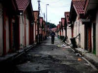 An unidentified man walks down an alley at a housing area in downtown Kuala Lumpur, Malaysia, Thursday, May 4, 2014.(
