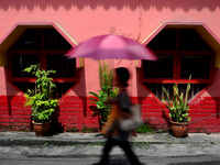 An unidentified woman walks pass a historical temple in downtown Kuala Lumpur, Malaysia, Thursday, May 4, 2014.(
