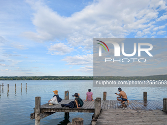 People Relaxing On The Shores Of Lake