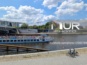 Cyclists By The River Spree In Berlin In Summer