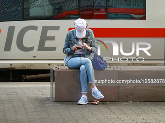 Young Woman Using Smartphone In Front Of ICE Train
