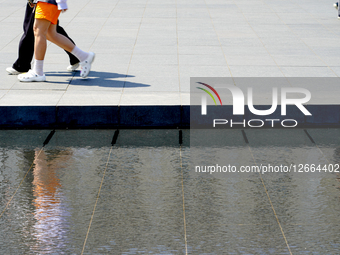 Pedestrians At Water Reflection