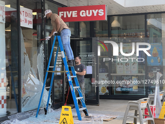 Workers Repair A Restaurant Window Damaged By Gunshots In Toronto