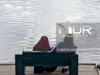 Couple Sitting On Bench By The Water 