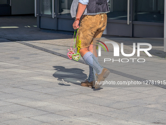 Man In Traditional Bavarian Attire Carrying Gingerbread Hearts