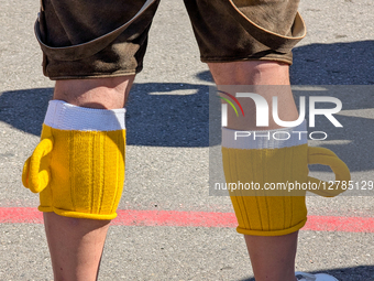 Man In Traditional Dress With Novelty Beer Mug Leg Warmers At Oktoberfest
