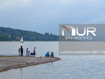 People At Lake In Autumn