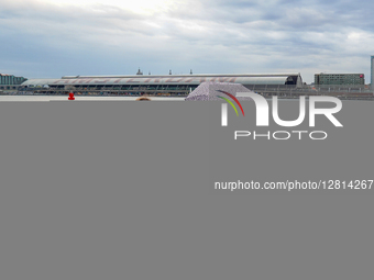 Two Women Sitting By The Waterfront With Umbrella