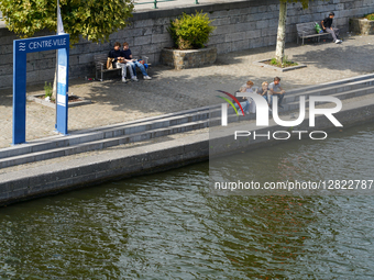 People Relaxing By Riverside