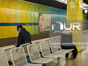 Passengers Using Smartphones At Metro Station
