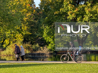 Senior Couple And Cyclist With Child In Autumn Park