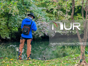 Man Fishing At Stream In Autumn