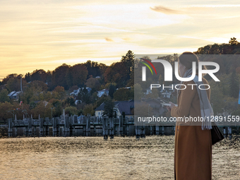 Woman Using Smartphone By Lake At Sunset