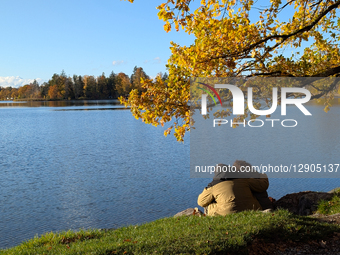Couple Embraces By Lake Under Autumn Foliage